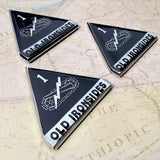 Three triangular metal 1st Armored Division emblems with 'Old Ironsides' on a textured surface.