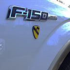 1st Cavalry Division Metal Auto Decal Color Badge under a F150 Lariat Decal on a white fender