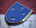 The Americal Division Metal Emblem on a red, white and blue background