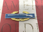Decorative item with a rifle on a blue bar against a red and white striped background