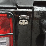 Close-up of a vehicle with an Airborne emblem on a wet surface