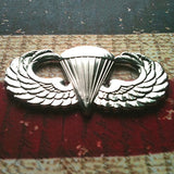 Parachutist Badge Jump Wings Metal Decal on a textured surface