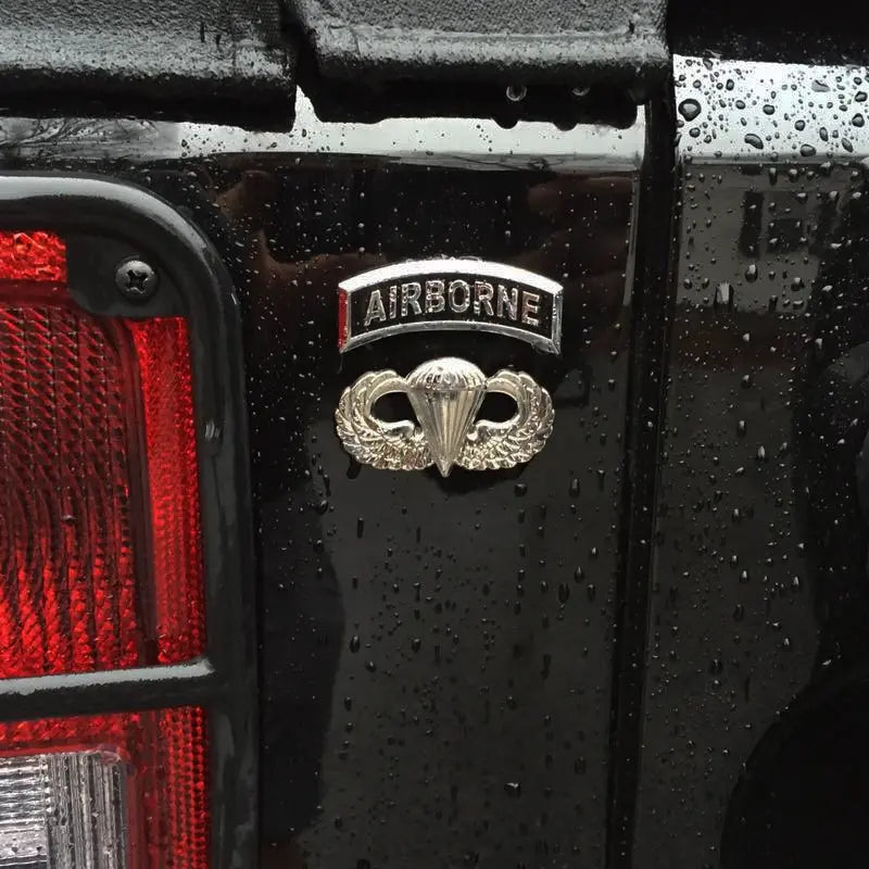 Airborne Tab Metal Decal With Jump Wings Decal on Black Truck
