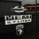 Chrome HEMI 5.7 Liter badge with Airborne logo on a dark background