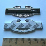 Combat Infantryman Badge Metal Car Decal First Award with 3M tape and a ruler for scale on a light blue background