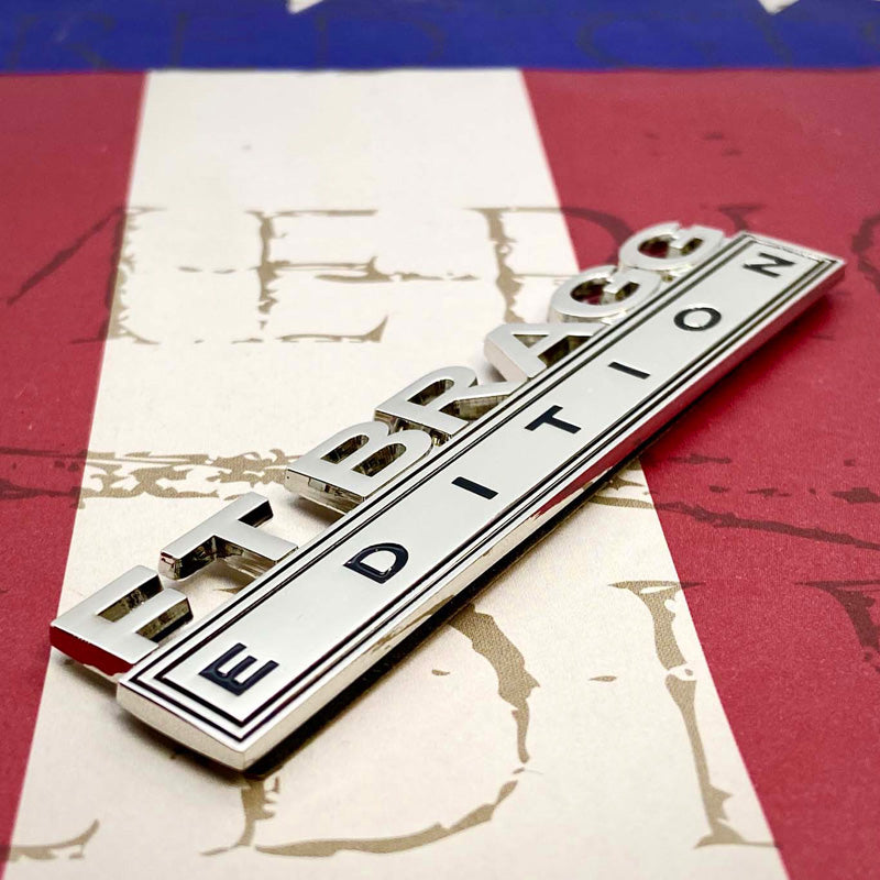 Ft Bragg Edition Metal Auto Decal on a left angle on a red, white and blue background