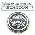 Metallic 'Veteran Edition' emblem with skull and parachute design on a white background