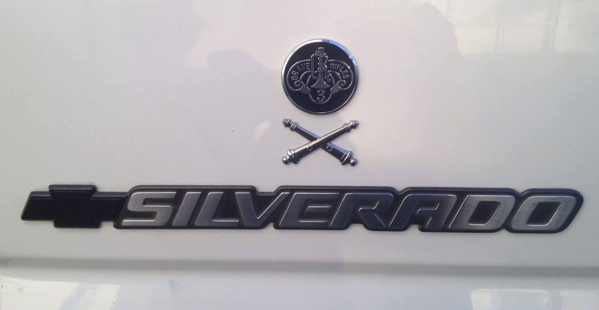 3rd Cavalry Regiment Brave Rifles Metal Car Emblem With Artillery Insignia Decal Above a Chevy Silverado Logo
