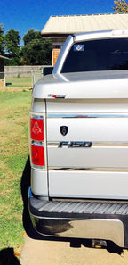 8th Infantry Division Metal Auto Emblem Above a F-150 Decal on a white tailgate