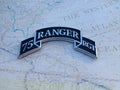 A black and silver scroll badge with the text '75 Ranger Regt' on a map background.