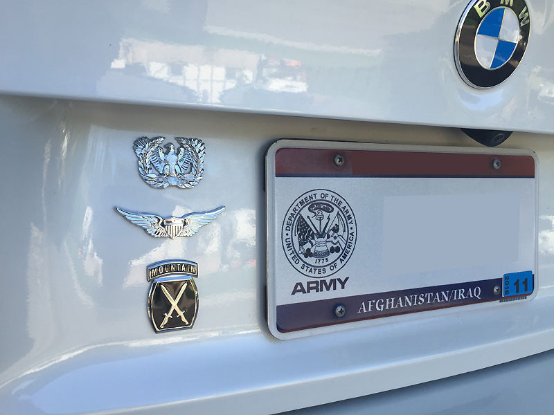 A close-up of a US Army Aviator Badge attached to a vehicle, showing chrome plating and the emblem of the U.S. Army.